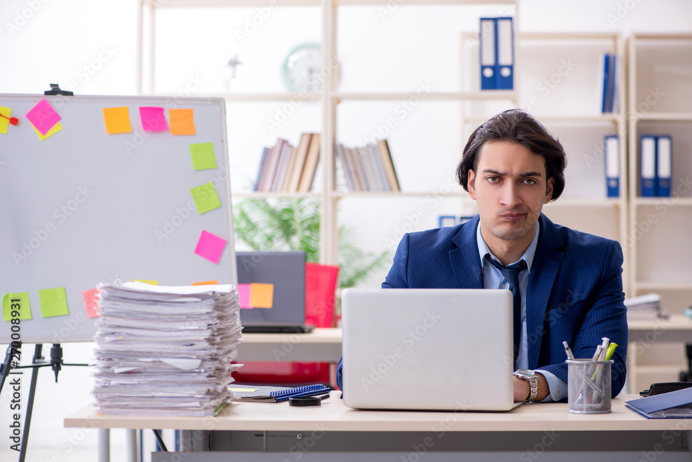 Young male employee unhappy with excessive work 