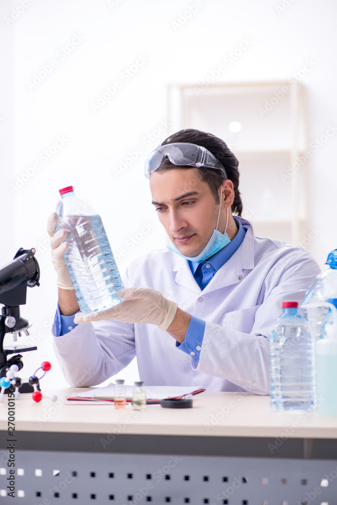 Young male chemist experimenting in lab Young male chemist experimenting in lab