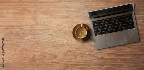 Laptop with coffee on wooden table. panoramic banner