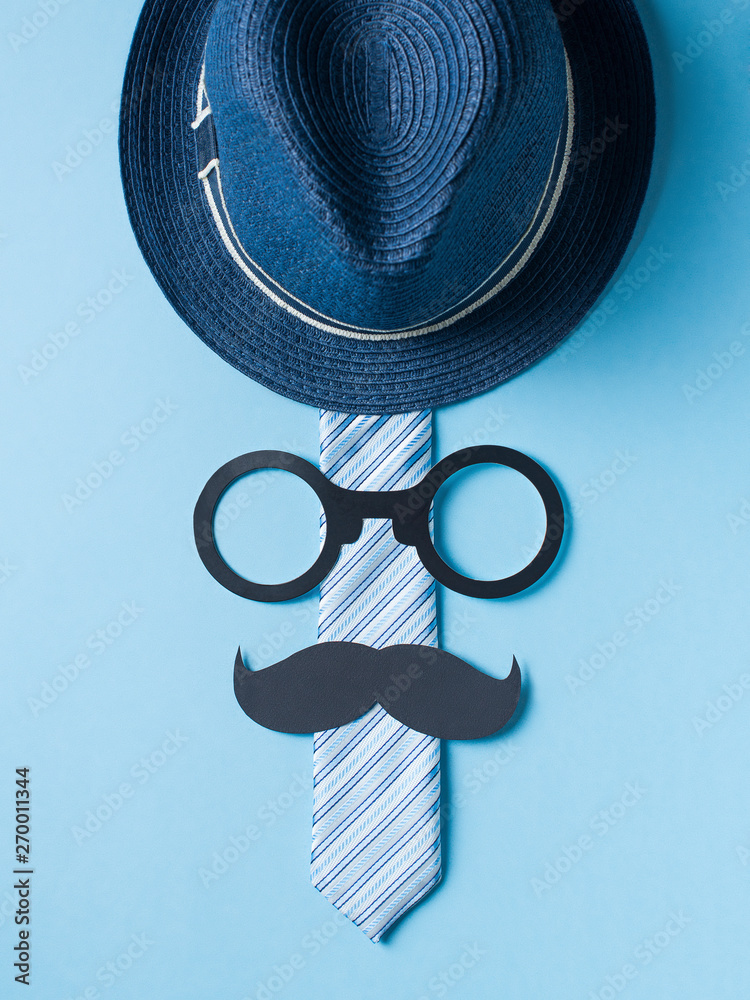 Fathers day concept with hat, glasses and tie on blue background - obrazy, fototapety, plakaty 