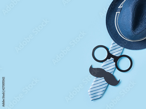 Fathers day concept with hat, glasses and tie on blue background