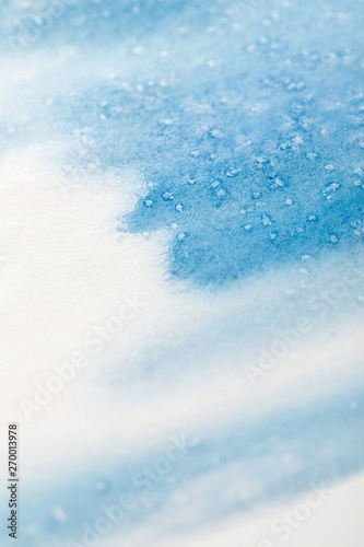 close up view of blue watercolor paint brushstrokes with dots on white background