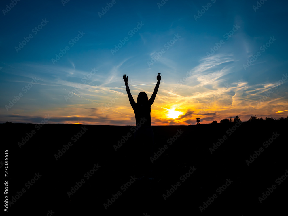 Junge Frau mit erhobenen Händen im Sonnenuntergang, Reise, Freiheit