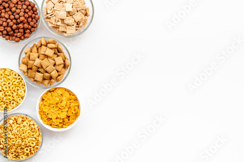 Various cereals in bowls on white background top view copyspace