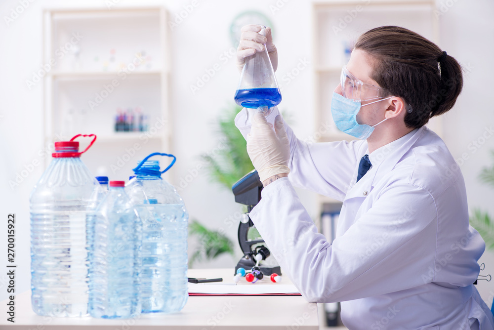 Fototapeta premium Young male chemist experimenting in lab