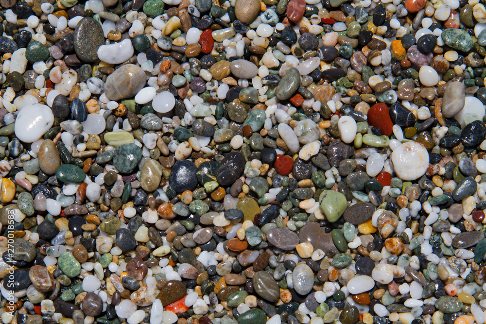 Colorful small rounded wet pebbles on a shingle beach Colorful small rounded wet pebbles on a shingle beach