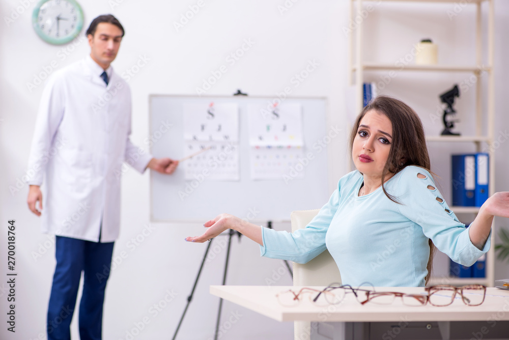 Fototapeta premium Young woman visiting male doctor oculist 
