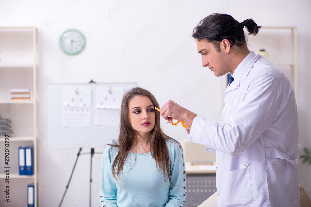 Fototapeta premium Young woman visiting male doctor oculist 