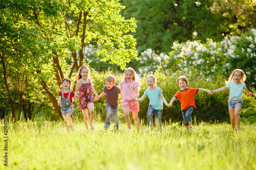 Φωτογραφία a group of children playing and running in the park on a green gozon