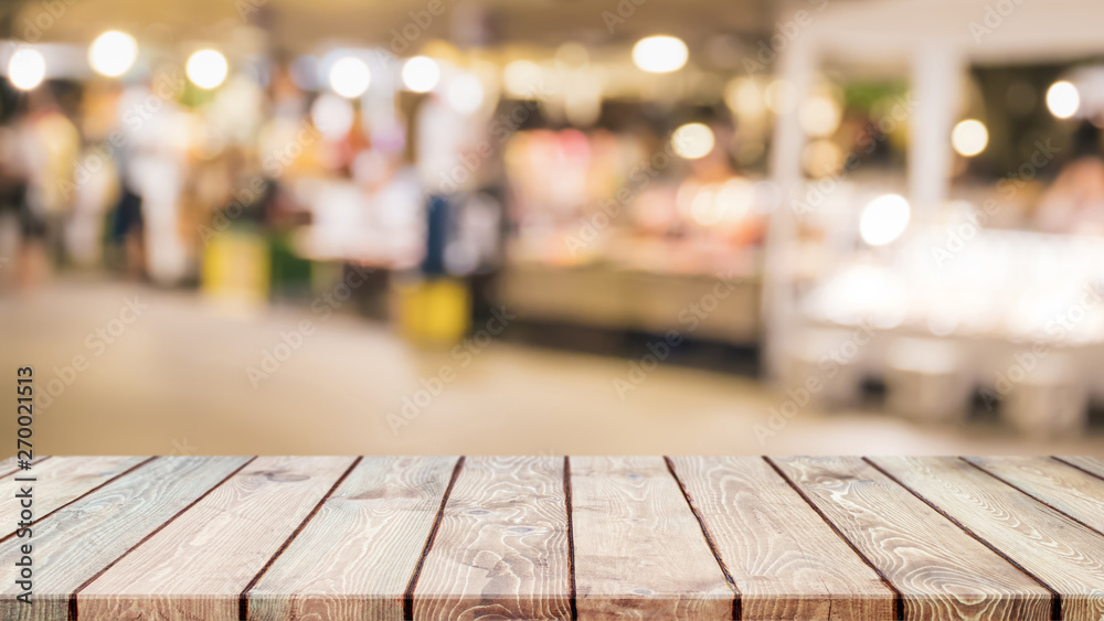 Empty wood table top on abstract blurred restaurant and street food lights background - can be used for display or montage your products Empty wood table top on abstract blurred restaurant and street food lights background - can be used for display or montage your products
