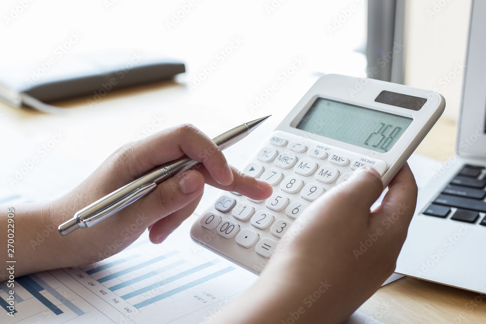 The company's female accountant is checking the company's financial account. Use the calculator to calculate income and expenses. The company's female accountant is checking the company's financial account. Use the calculator to calculate income and expenses.