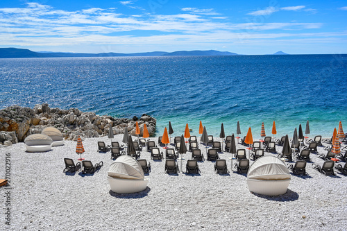 empty stone beach with sunshades in Rabac Croatia photo