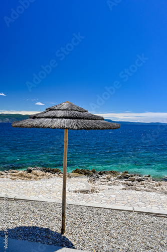 Fototapeta Naklejka Na Ścianę i Meble -  empty stone beach with sunshades in Rabac Croatia