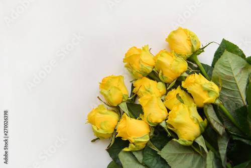 bouquet fresh yellow roses flowers with leaves white background. Flat lay, top view. corner frame composition. postcard birthday celebration father's day, mother's day, birthday floral arrangement