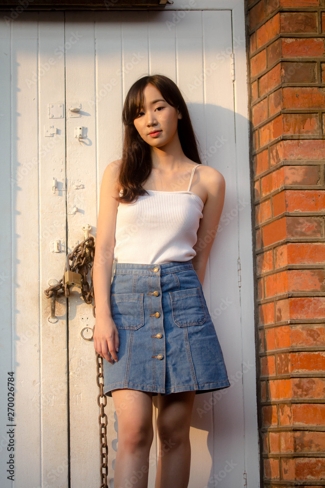 Fototapeta premium Portrait of thai china adult beautiful girl White shirt blue jeans relax and smile
