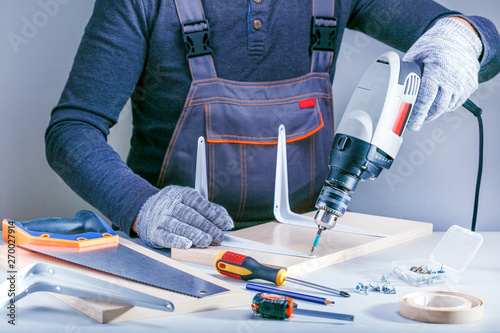 Closeup portrait of male hands making furniture in carpenters workshop. Concept Furniture assembly.