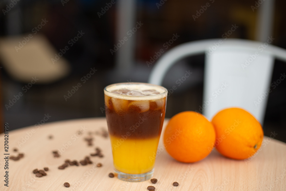 cold brew coffee with orange juice. Glass with cold coffee and ice on the street cafe background. Selective focus cold brew coffee with orange juice. Glass with cold coffee and ice on the street cafe background. Selective focus
