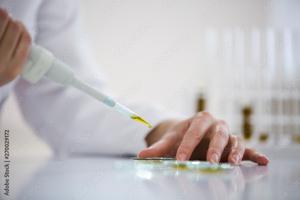 Checking a pharmaceutical cbd oil in a laboratory on watch glass Checking a pharmaceutical cbd oil in a laboratory on watch glass