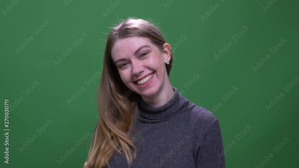 Pretty blonde model smiling happily into camera isolated on green chromakey background.