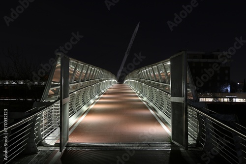 Pedestrian bridge illuminated at night.
