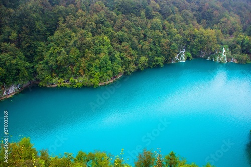 Top view of a large blue lake in Plitvice lakes national Park, Croatia. Beautiful landscape: clean blue water, forest, waterfalls. Amazing nature landscape, outdoor travel background.