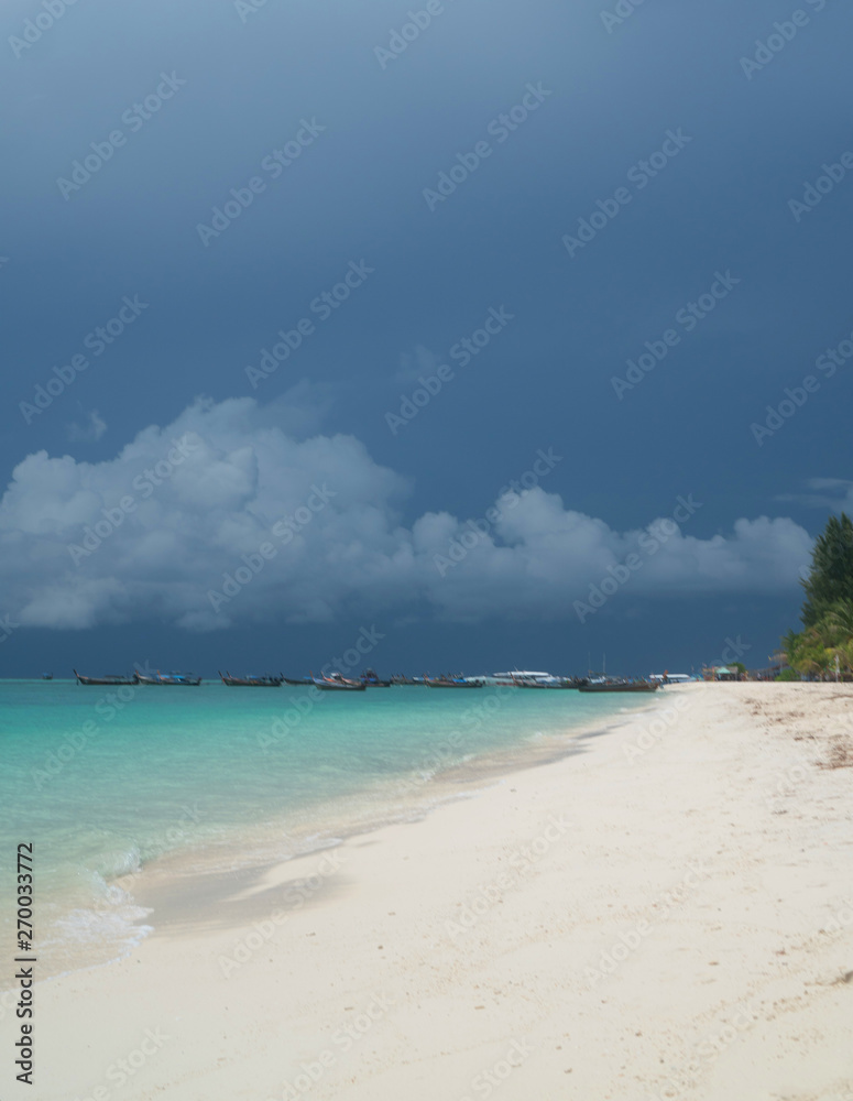 Sandy beach and sea with boats over cloudy sky. Koh Lipe beautiful tropical island in Thailand Sandy beach and sea with boats over cloudy sky. Koh Lipe beautiful tropical island in Thailand