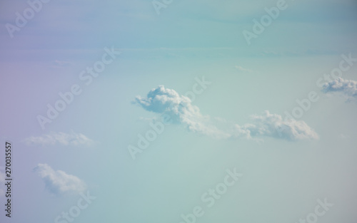 Aerial view from plane window with blue sky and white clouds