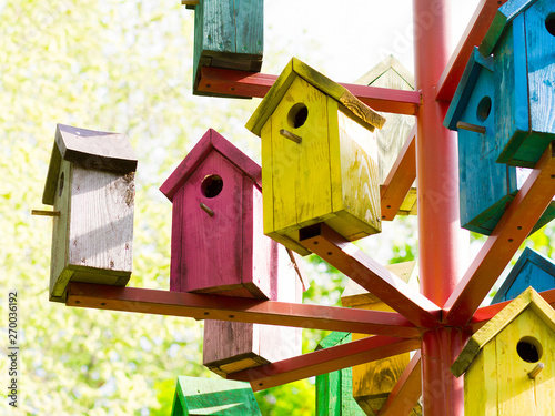 colorful birdhouses. many bright nesting boxes in the park. wooden bird houses