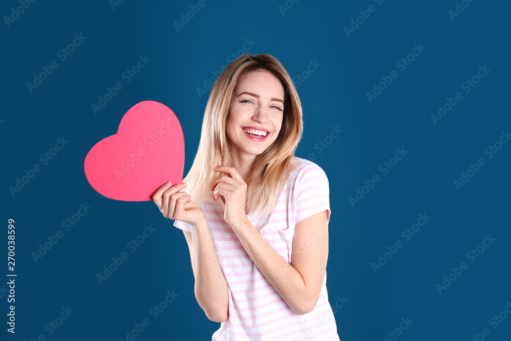 Portrait of pretty woman with heart shaped gift box on color background Portrait of pretty woman with heart shaped gift box on color background