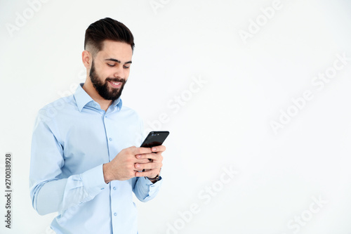 Handsome young man using phone on white background, space for text. Working time