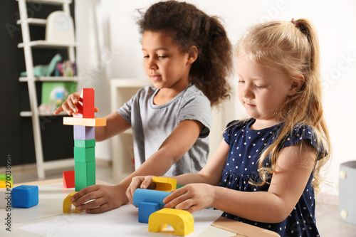 Canvas Print Cute little children playing with building blocks in kindergarten