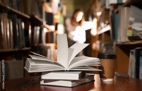 Books and cup of coffee on table in library © New Africa