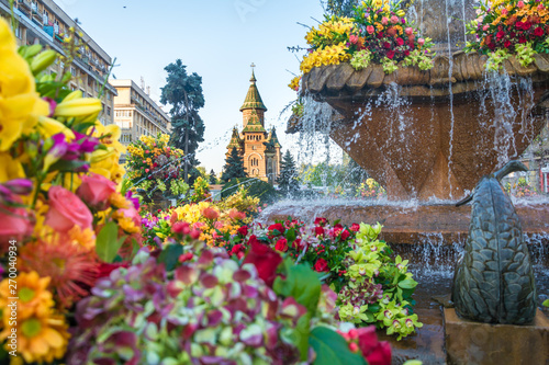 Beautiful old fountain with floral decorations in Victory Square, on the occasion of the "Flower Festival" organized by the City Hall. Beautiful floral decoration in European City. © kisarpad