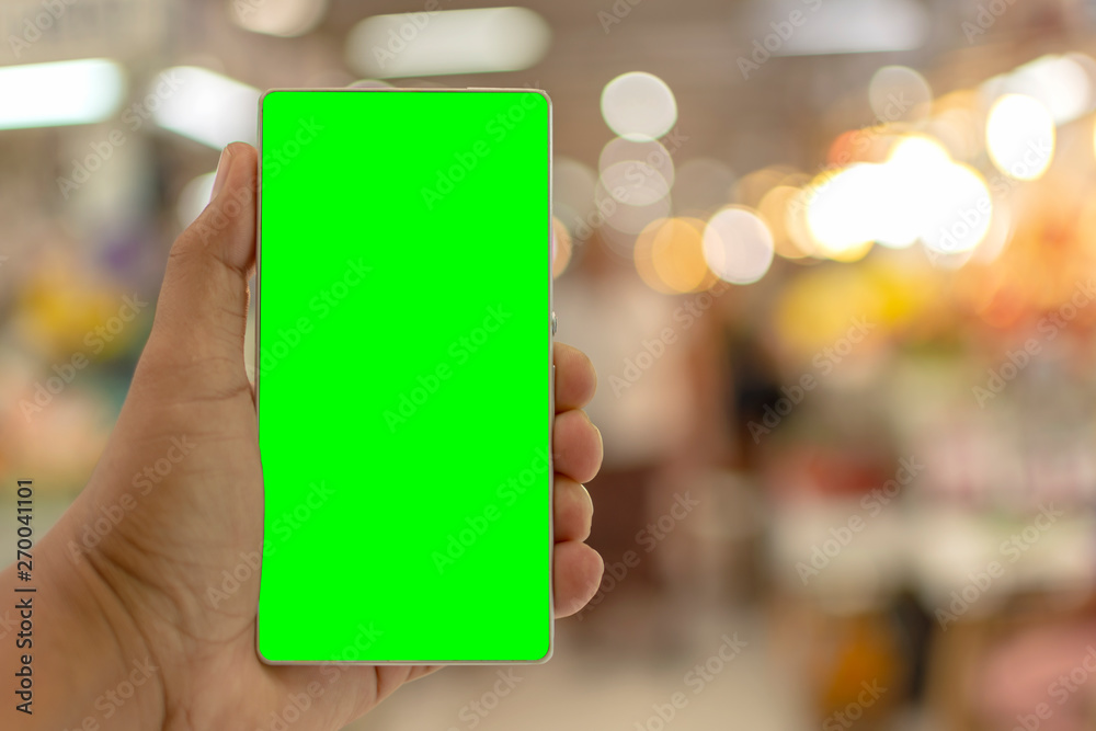 Man holding telephone with green screen for replacement with blur background Man holding telephone with green screen for replacement with blur background