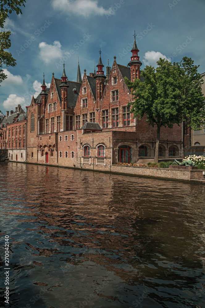 Fototapeta premium Brick buildings on the canal in a sunny day at Bruges