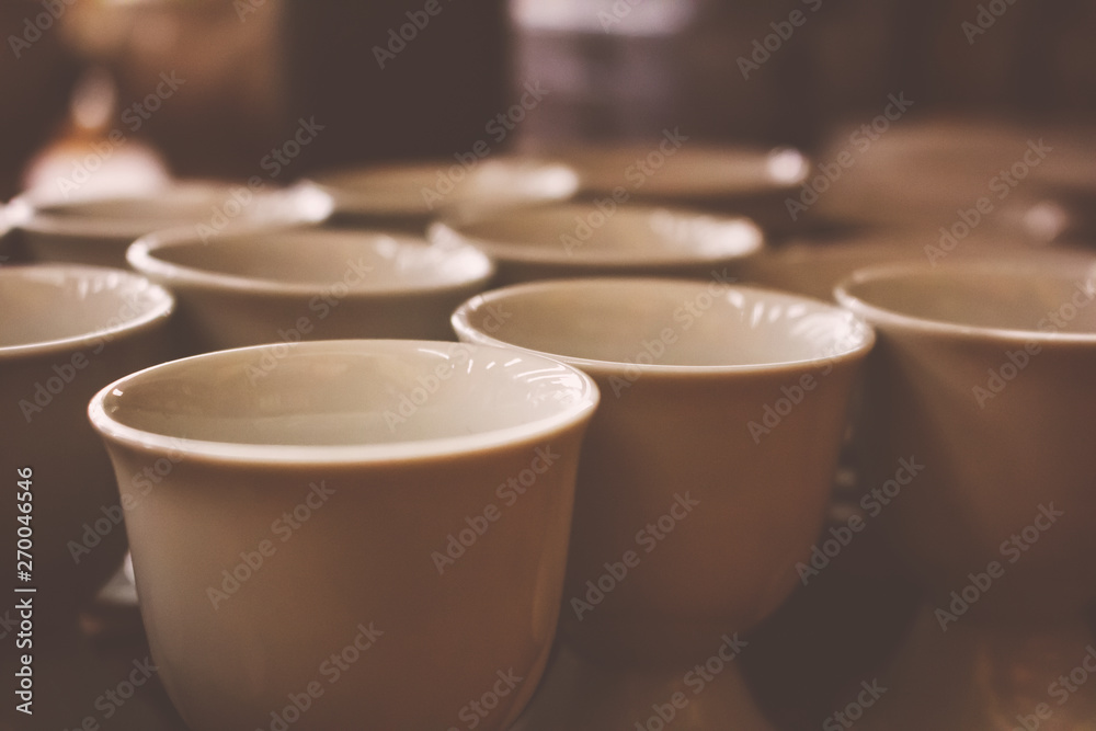 Several white ceramic cups in a restaurant environment Several white ceramic cups in a restaurant environment