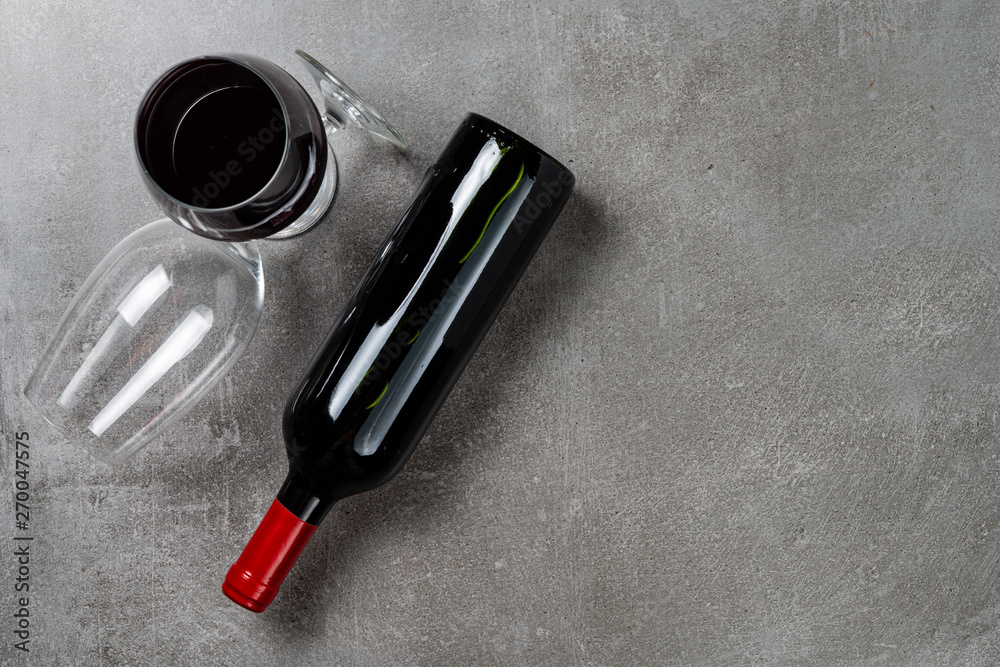 Naklejka premium Bottle of wine and glasses on concrete background. Copy Space.