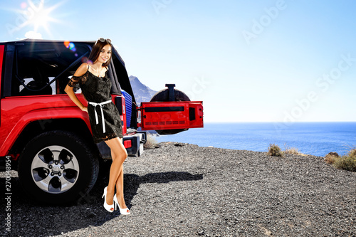 Slim young woman in summer car and sea landscape 