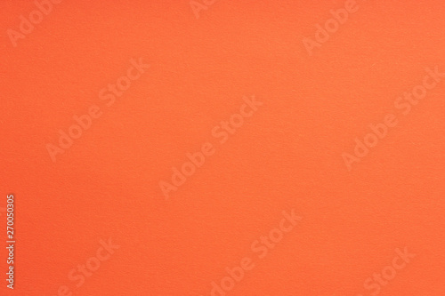 Paper background coral color. Rough paper texture. Closeup. Macro.