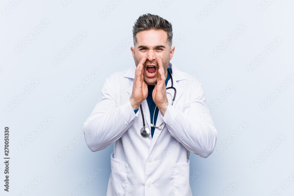 Young handsome doctor man shouting excited to front. Young handsome doctor man shouting excited to front.