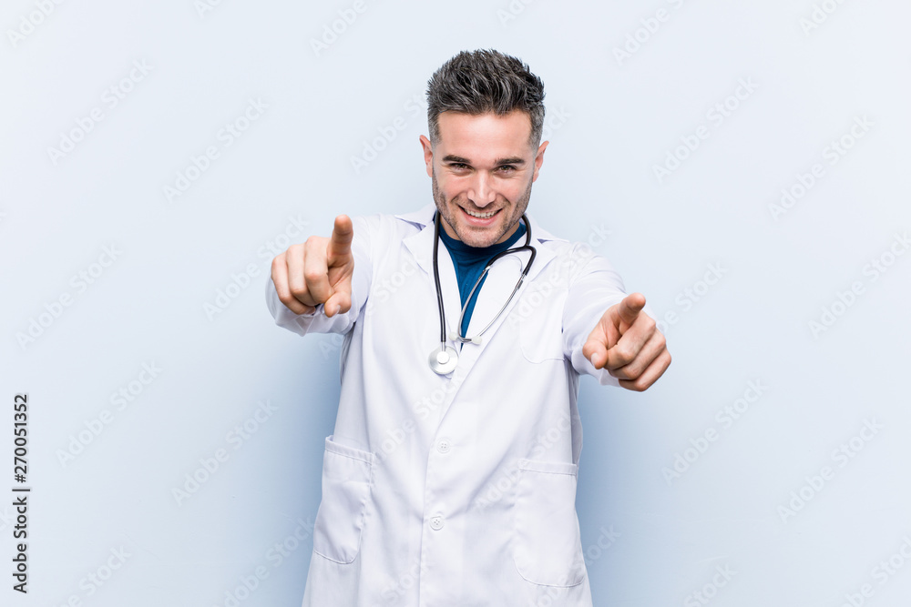Young handsome doctor man cheerful smiles pointing to front. Young handsome doctor man cheerful smiles pointing to front.
