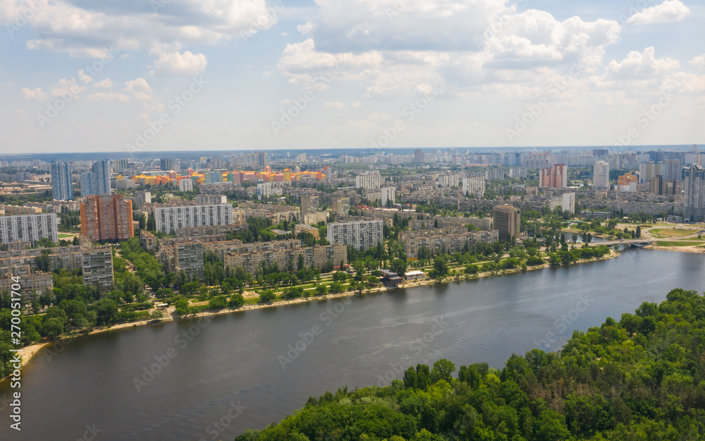 Urban aerial view photo from drone of cityscape, skyline and coastline of Dnieper River near Rusanivka island at summer time. (Kyiv, Kiev) Ukraine.
