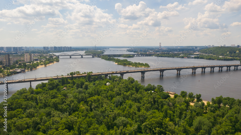 Aerial top view on road bridge across the Dnieper River in city at summer or spring time. (Kyiv, Kiev) Ukraine.