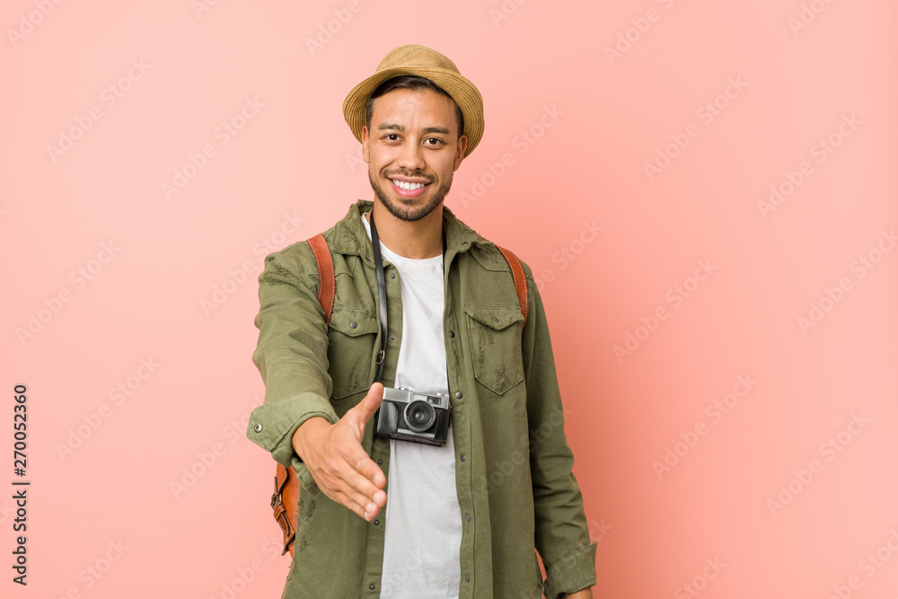 Young filipino traveler man stretching hand at camera in greeting gesture. Young filipino traveler man stretching hand at camera in greeting gesture.