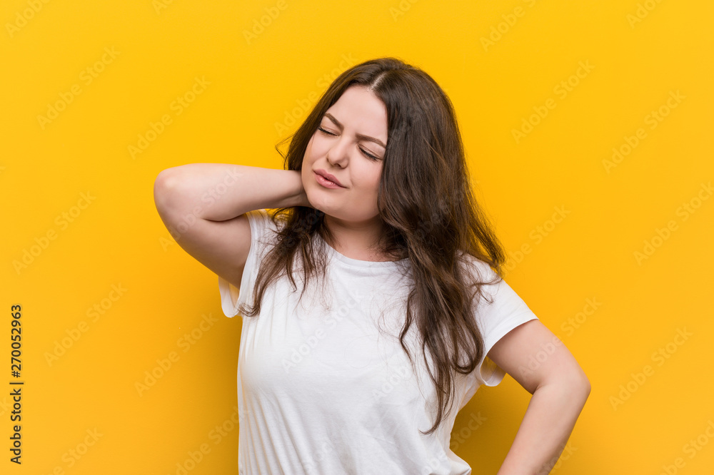 Young curvy plus size woman suffering neck pain due to sedentary lifestyle. Young curvy plus size woman suffering neck pain due to sedentary lifestyle.