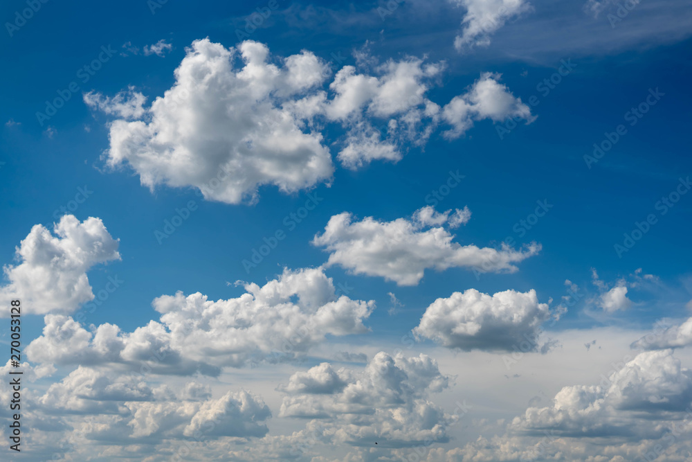 Beautiful blue sky with white clouds and a thin horizon line. Rays The sun breaks through the clouds Beautiful blue sky with white clouds and a thin horizon line. Rays The sun breaks through the clouds