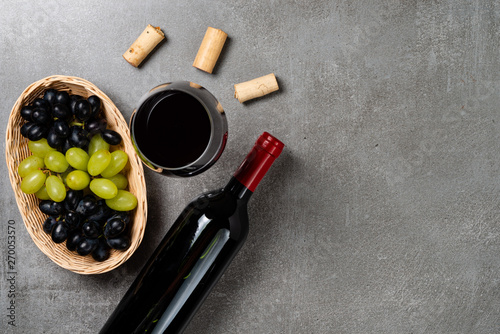 Basket with grapes and wine glass on concrete background. Copy Space.