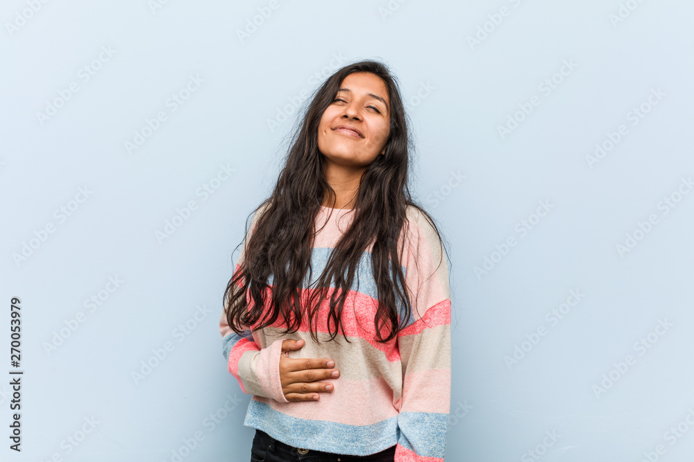 Young fashion indian woman touches tummy, smiles gently, eating and satisfaction concept. Young fashion indian woman touches tummy, smiles gently, eating and satisfaction concept.
