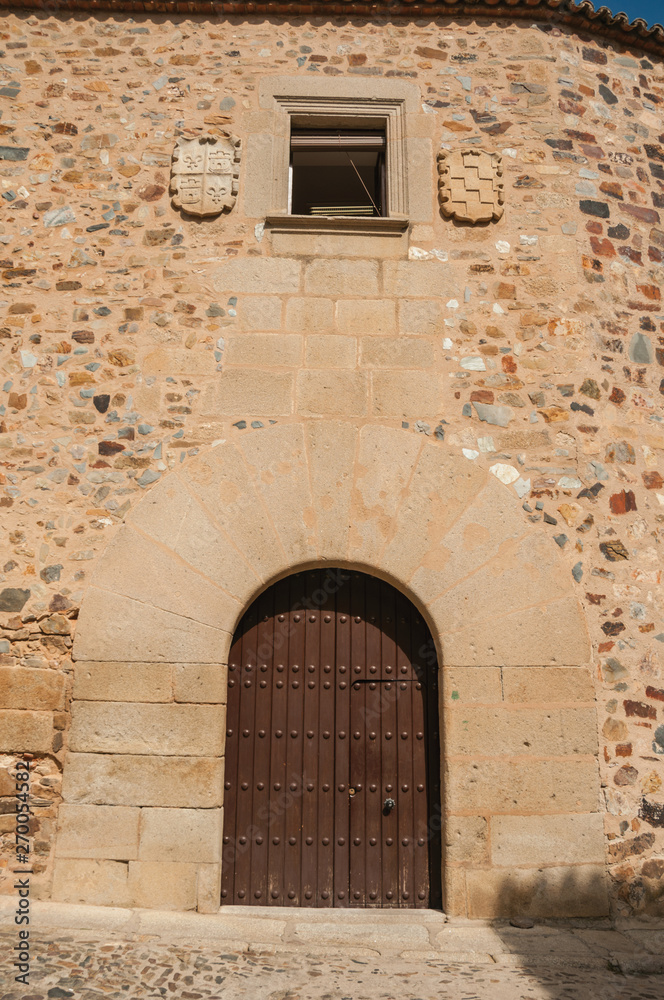Wooden door in old building facade with rounded top at Caceres Wooden door in old building facade with rounded top at Caceres