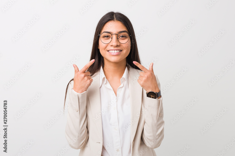 Young business arab woman isolated against a white background smiles, pointing fingers at mouth. Young business arab woman isolated against a white background smiles, pointing fingers at mouth.